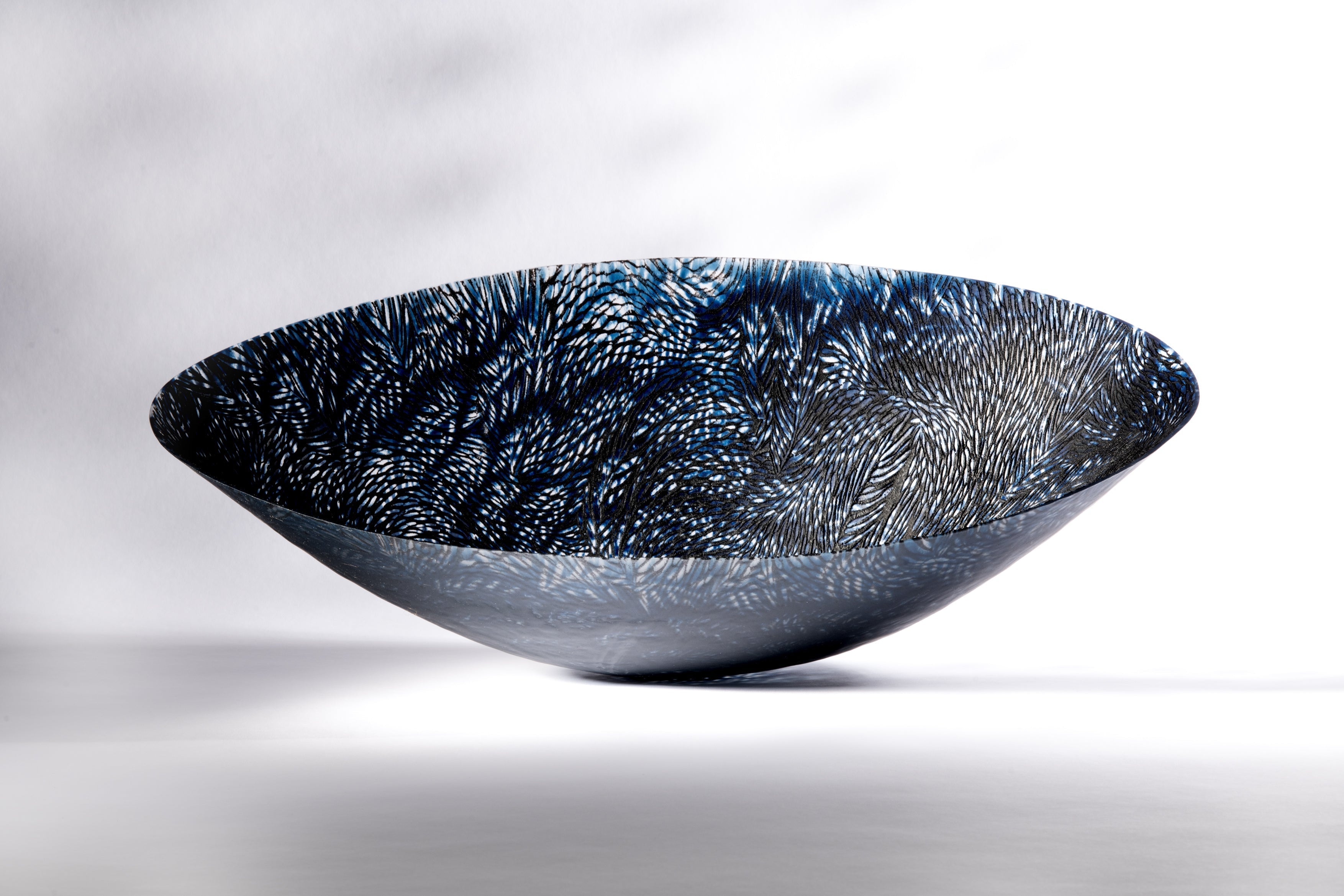 large kilnformed glass vessel in blue and black
